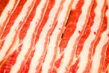 Seçici odaklı dilimlenmiş domuz eti arka planı. Popüler bir yemek tabağıdır ve kalın yağ dilimlerinden oluşur. Asya barbeküsü, Shabu Shabu ve sukiyaki yemek tarzı..