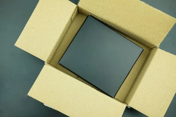 纸板箱纸箱中的黑色礼物 背景为黑色 — 图库照片