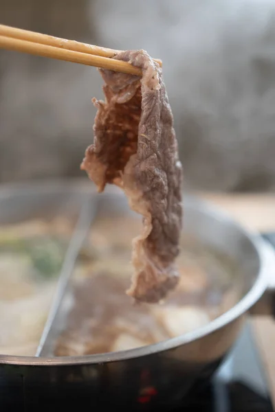 Mano Usando Palillos Recoger Carne Cruda Rodajas Sobre Sopa Olla — Foto de Stock