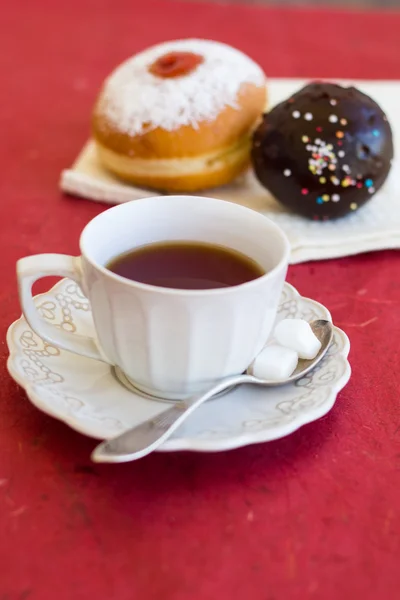 En kopp te med färska choklad donuts — Stockfoto
