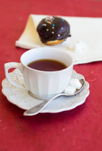 Una taza de té con rosquilla de chocolate fresco —  Fotos de Stock
