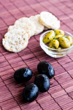 Bambu peçete üzerinde pirinç kek ile siyah ve yeşil zeytin