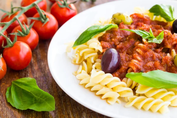 Pasta with tomato souse, olives and basil — Stock Photo, Image