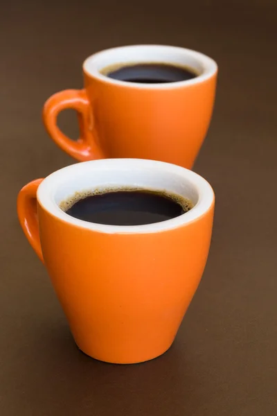 Two modern cups of coffee on a brown surface — Stock Photo, Image