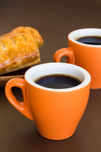 Two modern cups of coffee on a brown surface — Stock Photo, Image