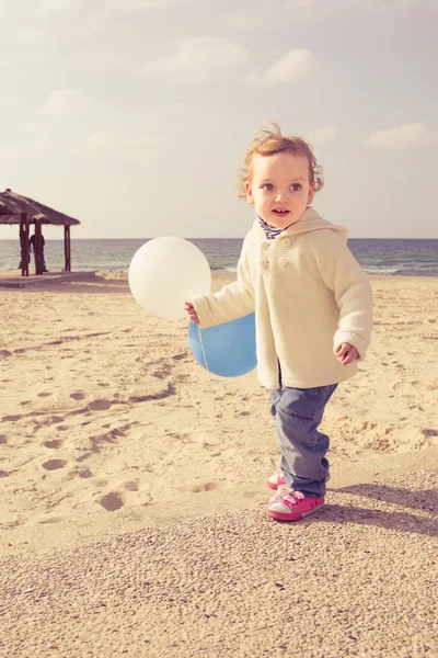 Красивая маленькая девочка играет на пляже — стоковое фото