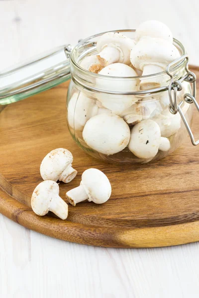 Frische Pilze in einem Glas auf einer Holzoberfläche — Stockfoto