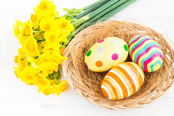 Easter eggs with yellow daffodils — Stock Photo, Image