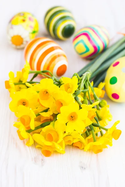 Желтые нарциссы с пасхальными яйцами — стоковое фото