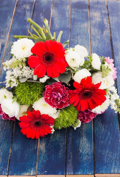 Bouquet of white, pink and red flowers on a wooden surface — Stock Photo, Image