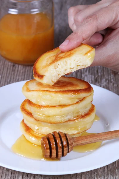 Pancakes with honey in hand — Stock Photo, Image