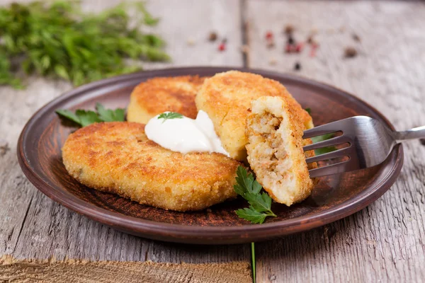 Potato patties with sour cream on the plate, stuffing — Stock Photo, Image