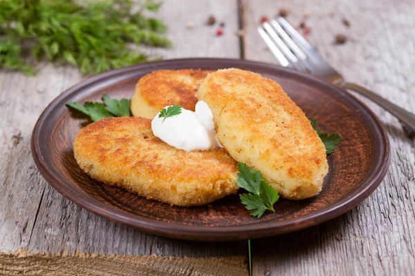 Potato patties with sour cream on a plate — Stock Photo, Image