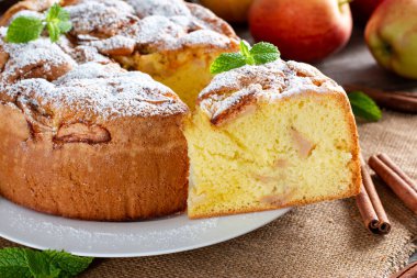 Elmalı sünger keki veya şifon keki, çok yumuşak ve lezzetli malzemelerle: yumurta, un, ahşap masadaki elmalar. Arkaplan ve duvar kağıdı için ev yapımı fırın kavramı.