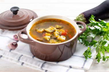 Beyaz bir masada mercimek ve sebzeli çorba..