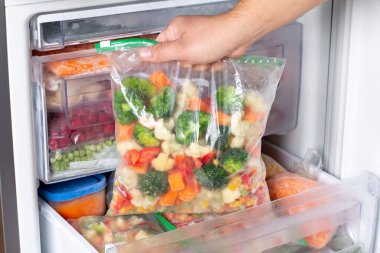 Buzdolabında farklı donmuş sebzeler olan plastik poşetler. Yiyecek deposu