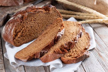 Ekmek, kırsal ahşap arka planda dilimlenmiş geleneksel ekşi ekmek. Geleneksel mayalanmış ekmek pişirme yöntemleri kavramı. Sağlıklı yemek..