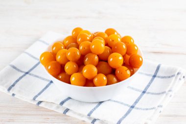 Masadaki beyaz kasede sarı kirazlı erik. Tkemali sosu yapmak için kiraz eriği.