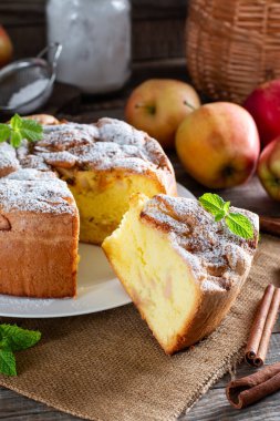 Elmalı sünger keki veya şifon keki, çok yumuşak ve lezzetli malzemelerle: yumurta, un, ahşap masadaki elmalar. Arkaplan ve duvar kağıdı için ev yapımı fırın kavramı.