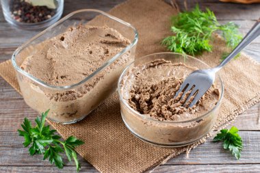 Ahşap bir masada cam bir kavanozda ciğer ezmesi.