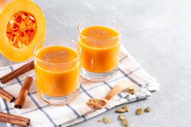 Balkabağı çekirdeği ve balkabağından yapılmış bir bardak sebze sütü. Yakın plan, balkabağı arka planda. Yatay, boşluğun kopyası