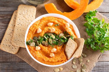 Masanın üzerinde sarımsak, limon ve biberli ev yapımı balkabağı humusu. Yukarıdan yatay üst görünüm