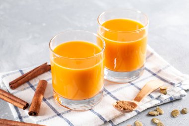 Hafif arka planda, yatay bir bardaktaki kabak tohumlarından çıkan sebze sütü.