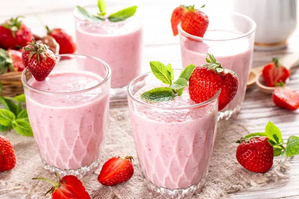Eski ahşap arka planda bir bardak taze çilekli smoothie. Sağlıklı yiyecek ve içecek konsepti
