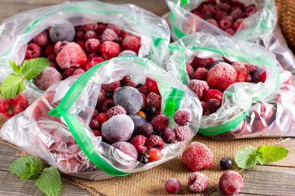 Mix Different Frozen Berries Plastic Bag Wooden Table Frozen Food — стоковое фото