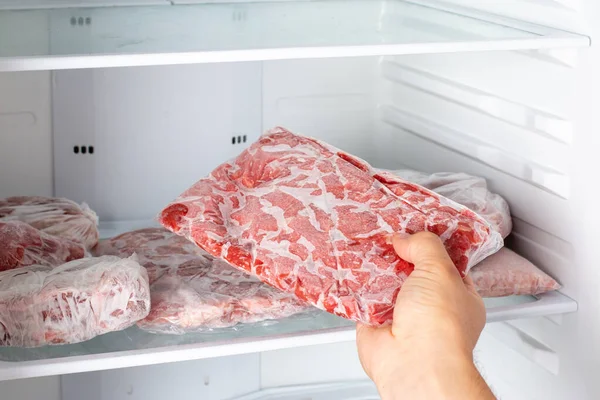 冷凍庫で新鮮な生肉を選択する手の閉鎖 冷凍食品 — ストック写真