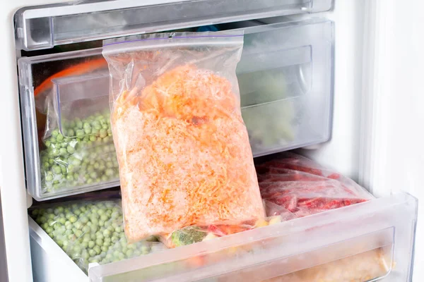 Frozen grated carrots in a bag in the freezer. Frozen food