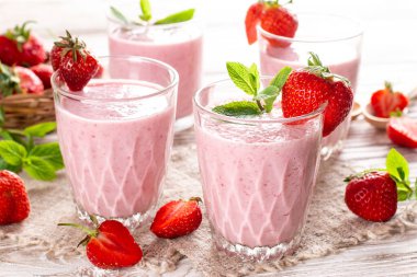 Masadaki cam kavanozda çilekli milkshake var. Meyve suyu ve taze çilek. Sağlıklı yiyecek ve içecek konsepti.