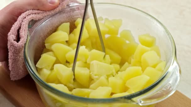 在玻璃壶中使用不锈钢马铃薯搅拌器用黄油或牛奶做泥的过程 — 图库视频影像