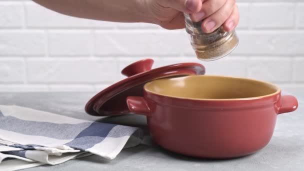 Male Hand Adds Pepper Dish Pepper Grinder Red Pot — Vídeo de Stock
