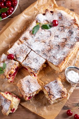 Tahta masada kirazlı sünger kek, seçici bir odak noktası. Ev yapımı kek.