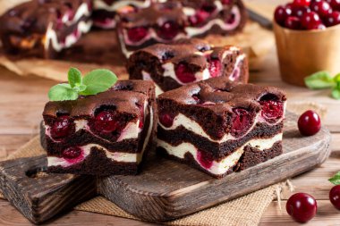 Chocolate cheesecake layered with brownie and dark cherrie. Chocolate cherrie cake. Pieces of chocolate cake. Traditional american cuisine. Still life of food.