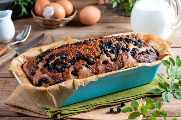 Home baked cake with blueberries on rustic wooden table