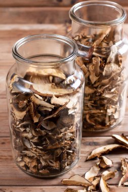 Collect and dry mushrooms in autumn, porcini mushrooms in a jar - a delicious ingredient for sauces and goulash on a rustic wooden table