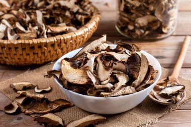 Dried mushrooms sliced, on a plate on an old wooden background