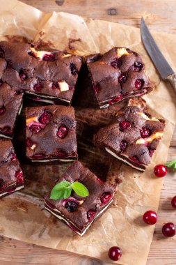 Chocolate cheesecake layered with brownie and dark cherrie. Chocolate cherrie cake. Pieces of chocolate cake. Traditional american cuisine. Still life of food.
