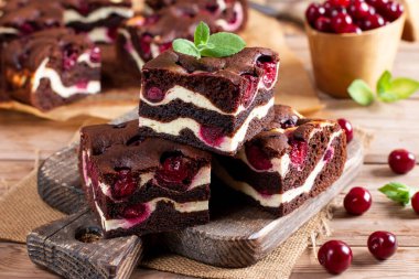 Chocolate cheesecake layered with brownie and dark cherrie. Chocolate cherrie cake. Pieces of chocolate cake. Traditional american cuisine. Still life of food.