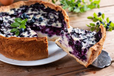 A piece of blueberry pie on rustic wooden table