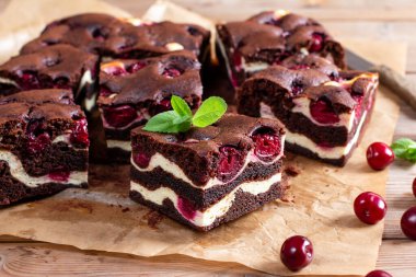 Brownie with cottage cheese and cherries on rustic wooden table