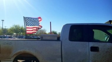 Shredded American Flag Flying on Back of Pickup Truck