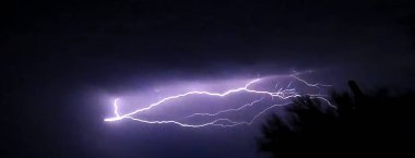 Karanlık gökyüzünde dallanmış yıldırımlar