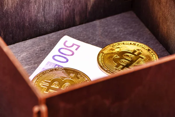 Bitcoins ve euro banknotları ahşap bir kutuda. Unutulmuş alım. Başarılı yatırım.
