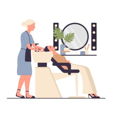 Kuaför, güzellik tedavisinden sonra müşterinin saçını yıkıyor.