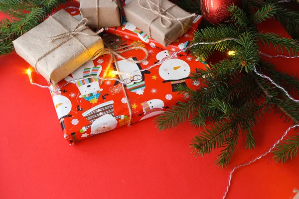 Kerstcompositie Met Geschenkdozen Touwspleten Papierrollen Decoraties Dennenboomtakken Rode Achtergrond Voorbereiding — Stockfoto