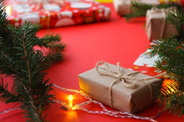 ギフトボックス ロープの爪 紙のロールと装飾 赤い背景のモミの木の枝を持つクリスマスの組成 休日の準備 コピースペース フラットレイアウト レイアウト フラット付きのトップビュー — ストック写真