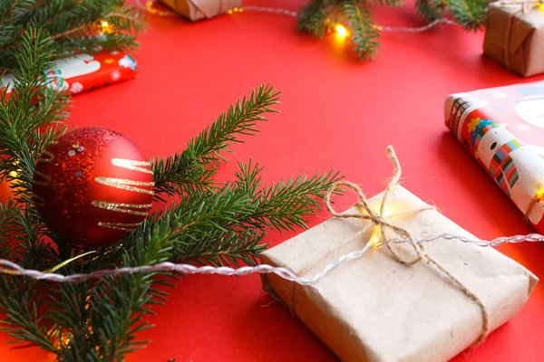 Weihnachtskomposition Mit Geschenkschachteln Seilklammern Papierrollen Und Dekorationen Tannenzweigen Auf Rotem — Stockfoto